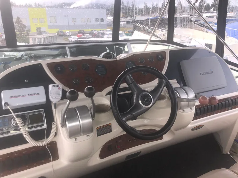 Slide: The Image of 2001 Maxum 4100 SCA yacht helm with steering wheel, controls, and Garmin navigation system. - 14