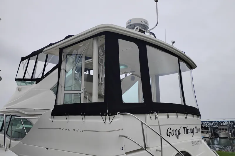 Slide: The Image of 2001 Maxum 4100 SCA yacht docked, featuring enclosed upper deck and radar equipment. - 4