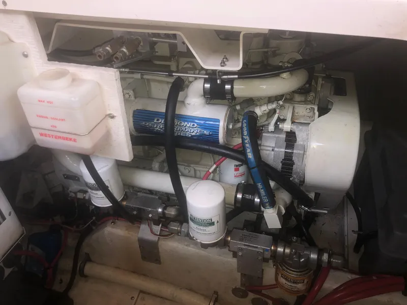 Slide: The Image of Engine compartment of a 2001 Maxum 4100 SCA boat, featuring mechanical components and hoses. - 49