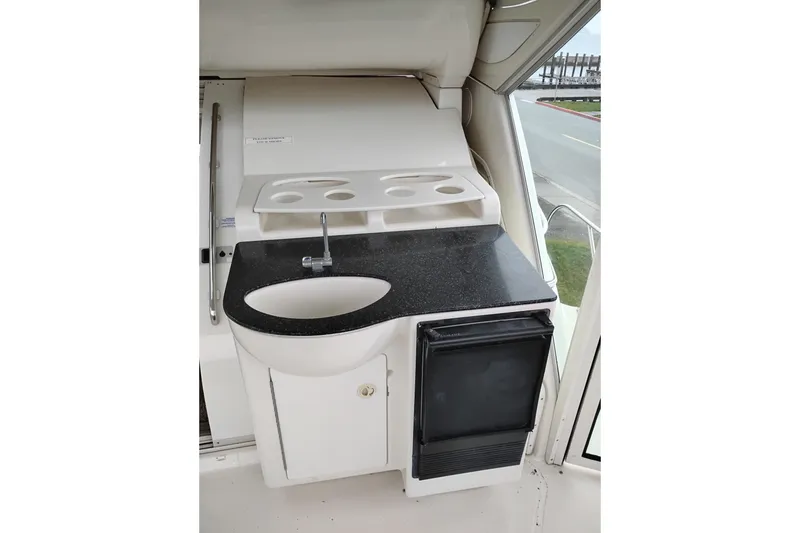 Slide: The Image of 2001 Maxum 4100 SCA yacht kitchenette with sink, countertop, and mini fridge. - 8