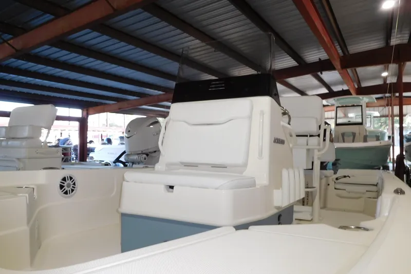 The Image of 2026 Skeeter SX230 boat interior under a metal roof, showcasing seating and storage. - 1