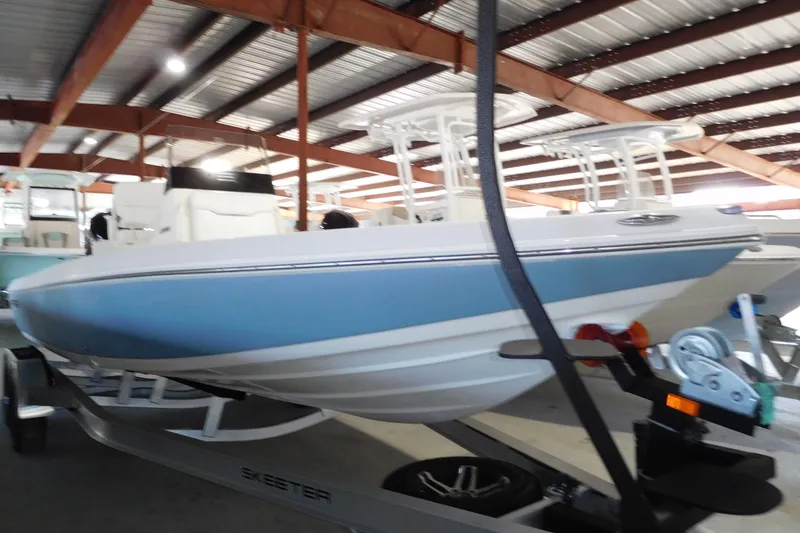 Slide: The Image of 2026 Skeeter SX230 boat in storage, featuring sleek design and blue accents. - 2