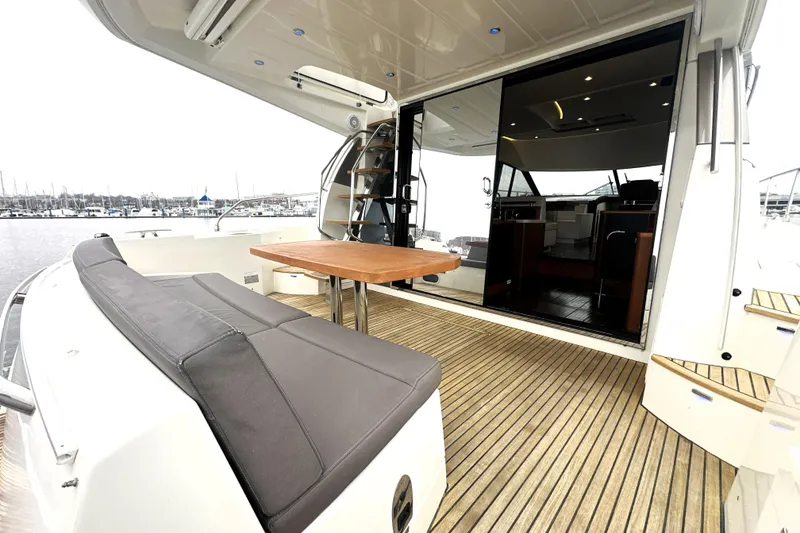 Slide: The Image of 2017 Prestige 500 yacht with spacious deck, seating, and sliding glass doors. - 10