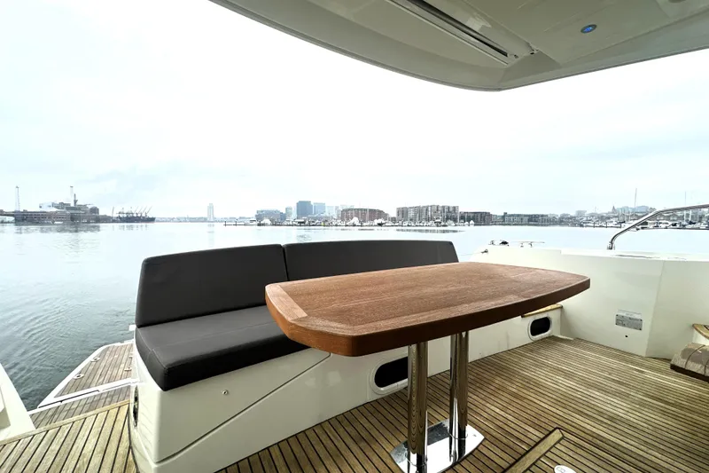 Slide: The Image of Luxury 2017 Prestige 500 yacht deck with wooden table and waterfront view. - 11