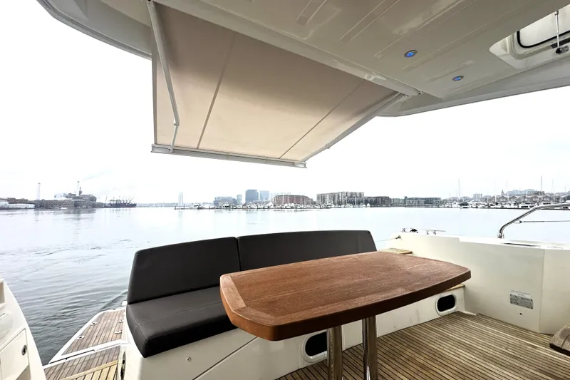 Slide: The Image of Luxury yacht deck with seating and table, Prestige 500, 2017 model, overlooking a serene waterfront. - 12