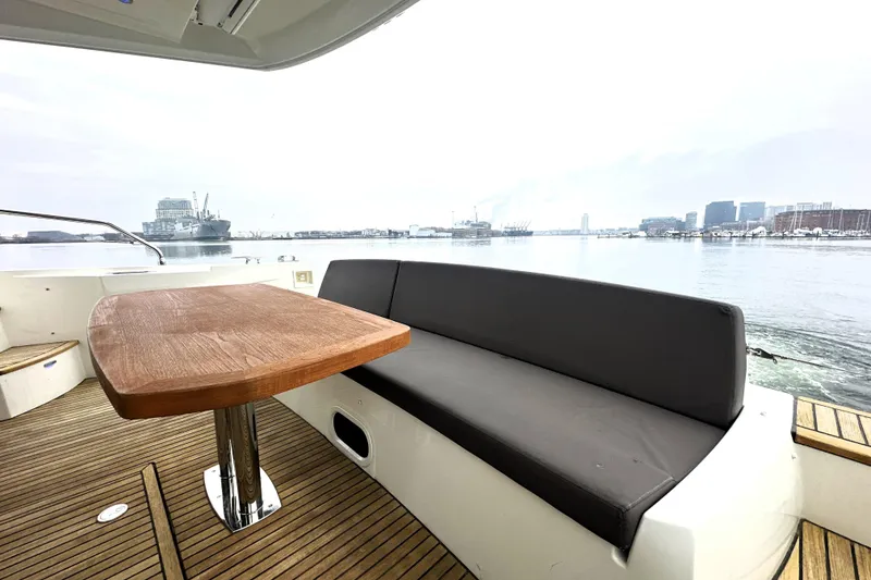 Slide: The Image of Luxury yacht deck with wooden table and seating, Prestige 500, 2017 model, overlooking a harbor. - 13