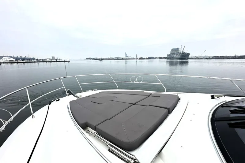 Slide: The Image of 2017 Prestige 500 yacht with sunpad, overlooking calm harbor waters. - 15