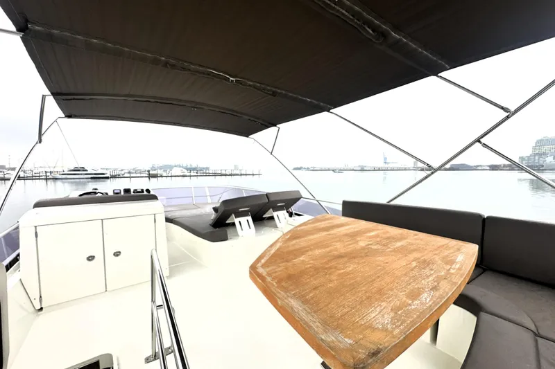 Slide: The Image of 2017 Prestige 500 yacht deck with seating, table, and canopy, docked at marina. - 18