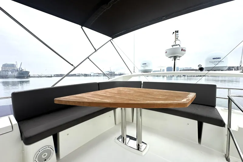 Slide: The Image of 2017 Prestige 500 yacht with outdoor seating and wooden table, docked in a marina. - 20