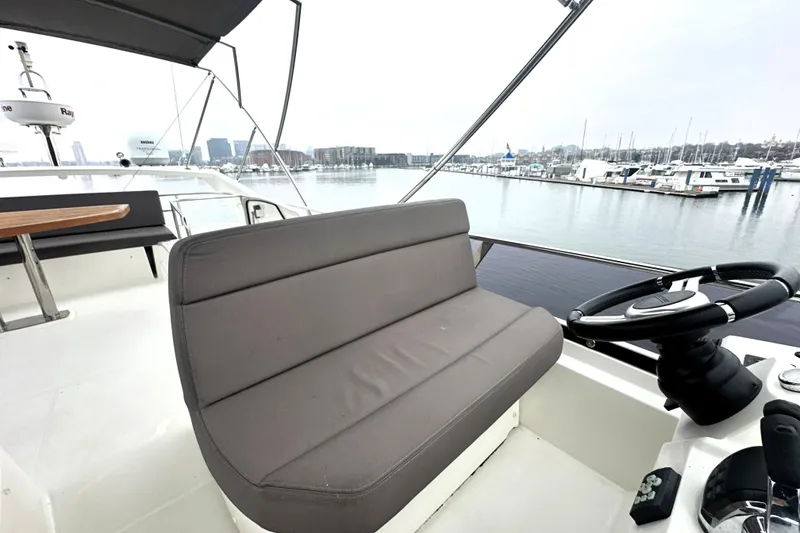 Slide: The Image of Flybridge of 2017 Prestige 500 yacht with helm and seating, overlooking marina. - 23