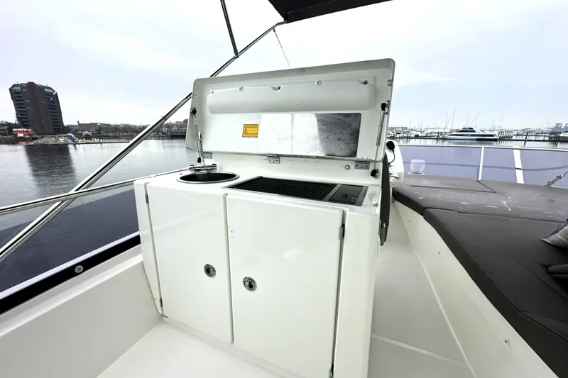 Slide: The Image of Outdoor kitchenette on 2017 Prestige 500 yacht, featuring grill and sink, dockside view. - 27