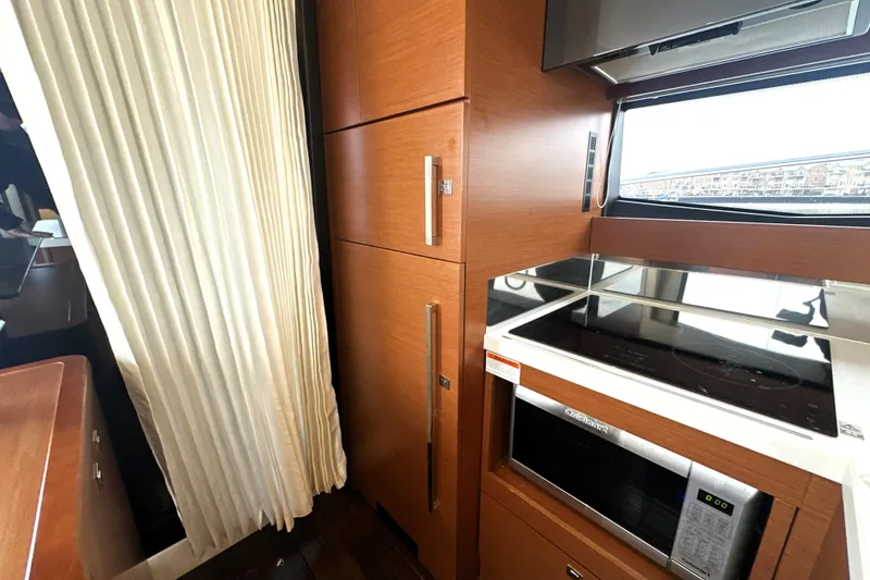 Slide: The Image of Modern kitchen interior on a 2017 Prestige 500 yacht, featuring wood cabinetry and appliances. - 34