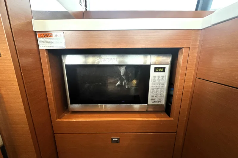 Slide: The Image of Built-in microwave in 2017 Prestige 500 yacht kitchen, featuring wood cabinetry. - 36