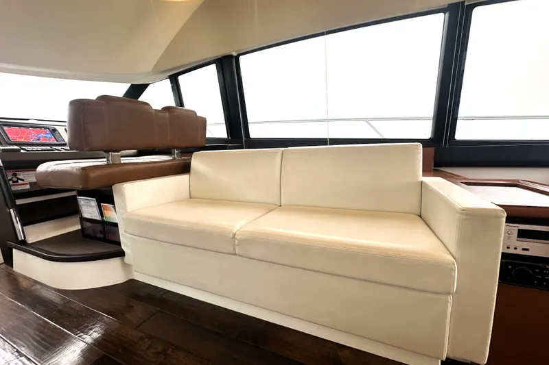 Slide: The Image of Luxurious interior of 2017 Prestige 500 yacht with white sofa and brown helm seats. - 40