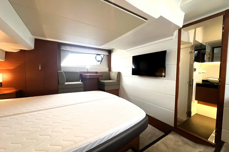 Slide: The Image of Luxurious 2017 Prestige 500 yacht interior with bed, seating, TV, and bathroom. - 62