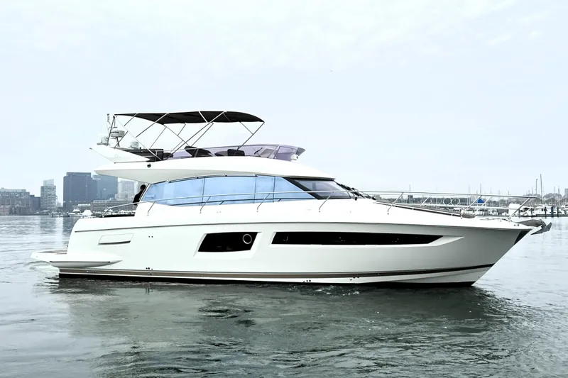 Slide: The Image of 2017 Prestige 500 yacht on calm water with city skyline in background. - 7