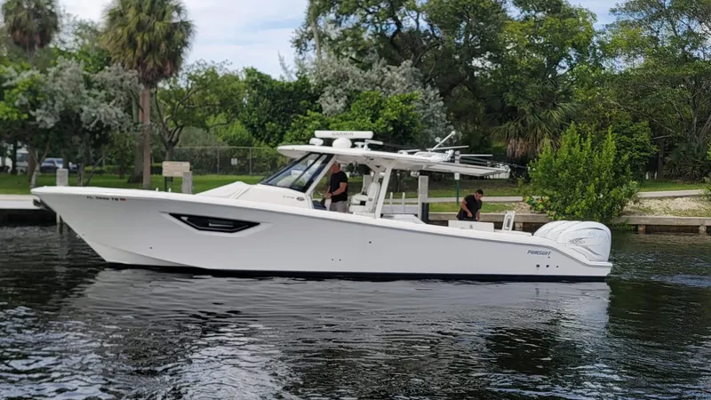 Slide: The Image of 2021 Pursuit S 378 Sport boat cruising on a calm river with lush greenery. - 14