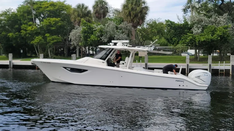Slide: The Image of 2021 Pursuit S 378 Sport boat on a calm river near a lush, green shoreline. - 15