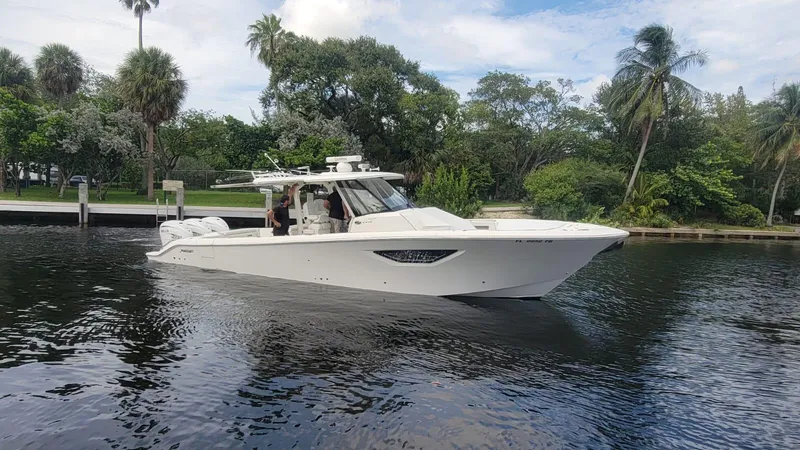 Slide: The Image of 2021 Pursuit S 378 Sport boat cruising on a calm river with lush greenery. - 17