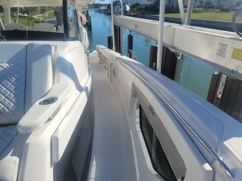 Slide: The Image of 2021 Pursuit S 378 Sport boat docked, featuring sleek white design and comfortable seating. - 22