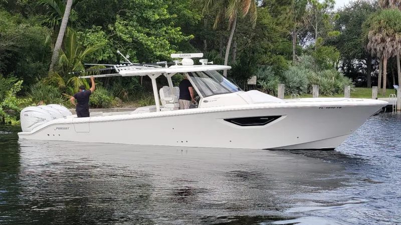 Slide: The Image of 2021 Pursuit S 378 Sport boat cruising on a calm river, surrounded by lush greenery. - 6