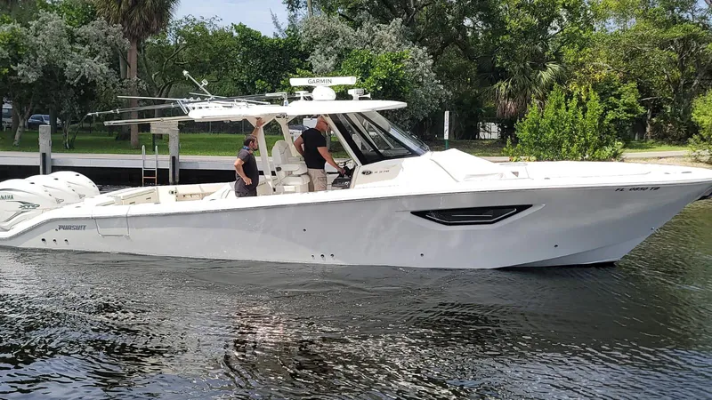 Slide: The Image of 2021 Pursuit S 378 Sport boat on calm water with lush greenery background. - 7
