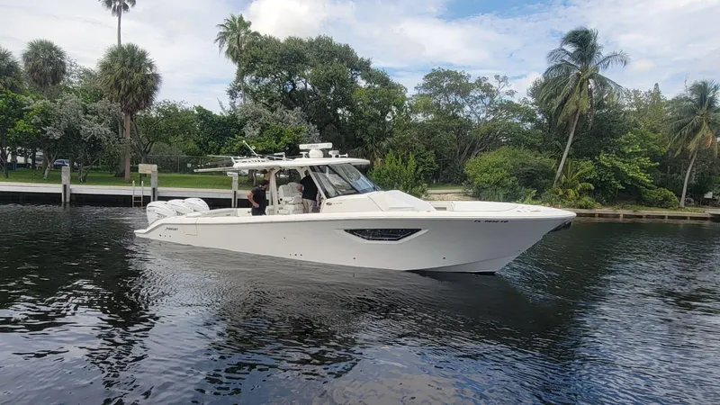 Slide: The Image of 2021 Pursuit S 378 Sport boat cruising on a calm river with lush greenery. - 8
