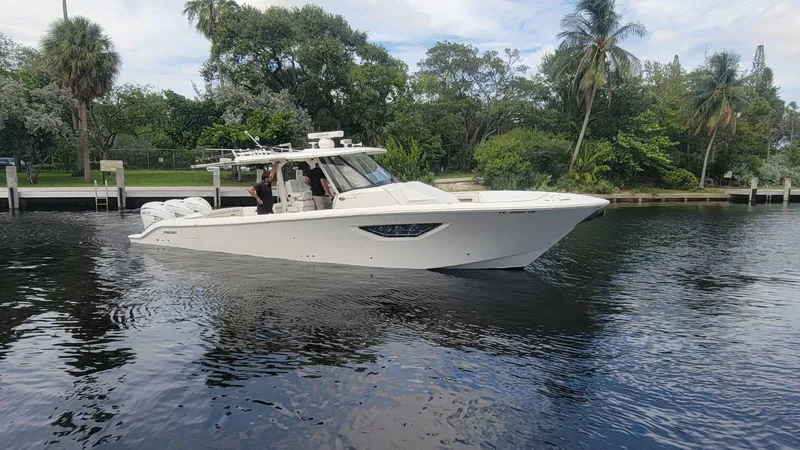 Slide: The Image of 2021 Pursuit S 378 Sport boat cruising on a calm river with lush greenery. - 9