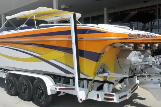Slide: The Image of 2013 Nordic 39 POKER RUN boat with vibrant orange and yellow design on trailer. - 6