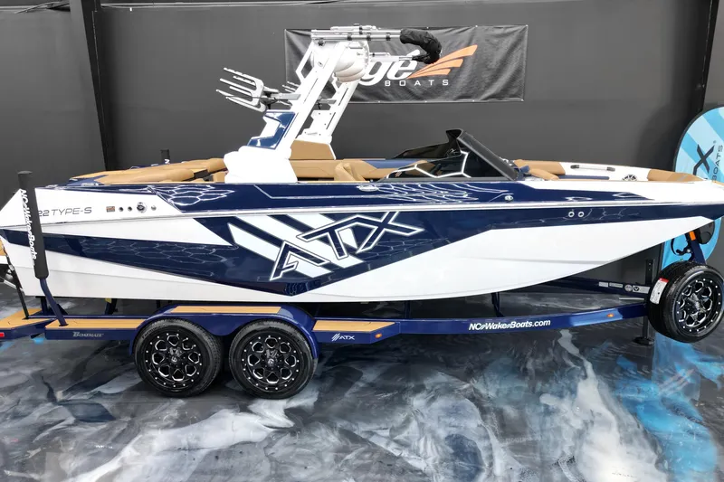Slide: The Image of 2024 ATX Surf Boats 22 Type-S, blue and white, displayed indoors on a trailer. - 12