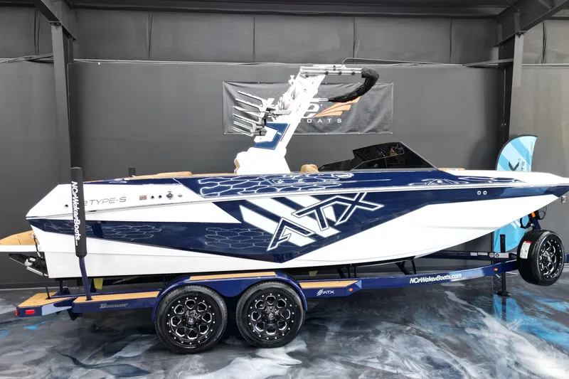 Slide: The Image of 2024 ATX Surf Boats 22 Type-S, sleek design, displayed indoors on a trailer. - 2
