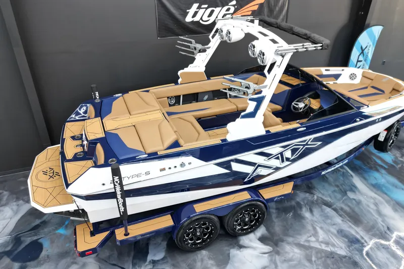 Slide: The Image of 2024 ATX Surf Boats 22 Type-S, blue and tan design, displayed indoors on a trailer. - 5