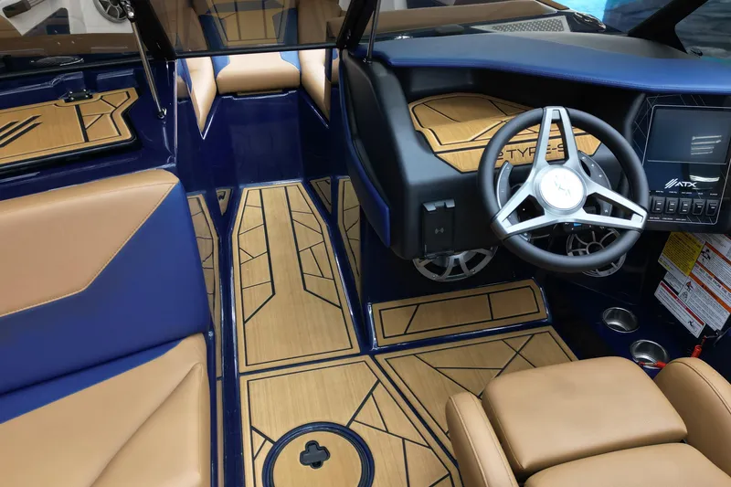 Slide: The Image of 2024 ATX Surf Boats 22 Type-S interior with tan and blue seating, modern dashboard, and steering wheel. - 9
