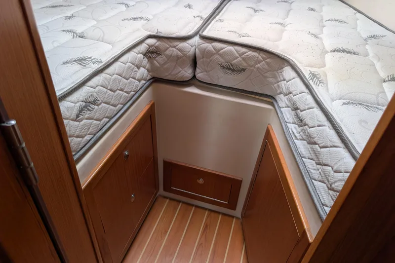 Slide: The Image of Interior of 2021 Catalina 315 sailboat with wooden steps and cozy sleeping area. - 21