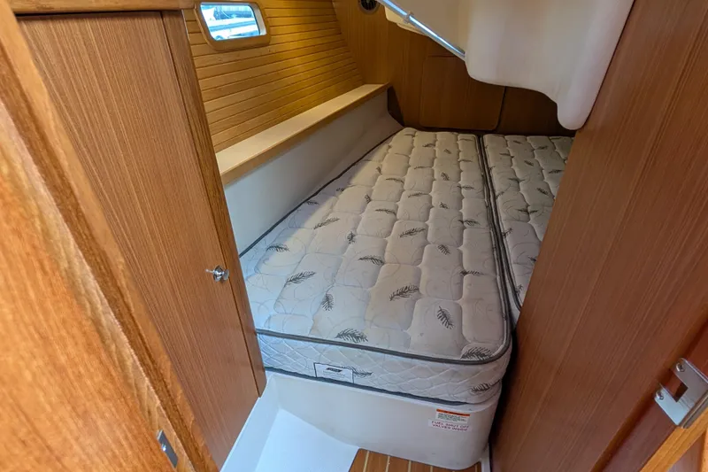 Slide: The Image of 2021 Catalina 315 yacht cabin with comfortable mattress and wooden interior. - 22