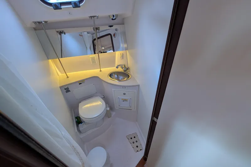 Slide: The Image of 2021 Catalina 315 yacht bathroom with toilet, sink, and mirror. - 24