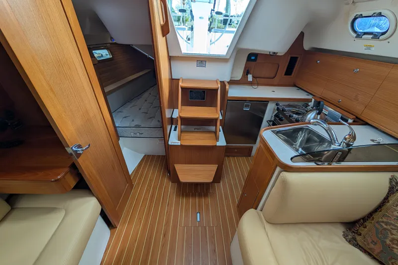 Slide: The Image of Interior of 2021 Catalina 315 sailboat with kitchen, seating, and sleeping area. - 3