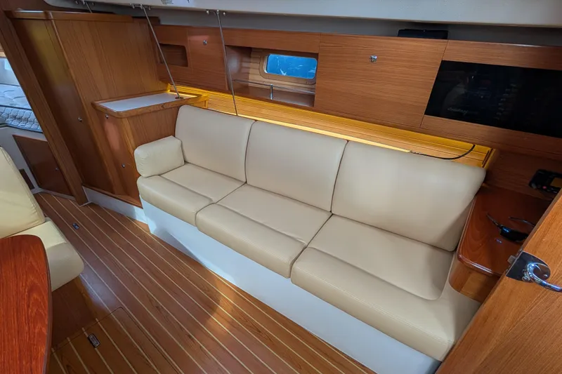 Slide: The Image of Interior of 2021 Catalina 315 yacht with beige leather sofa and wooden cabinetry. - 4