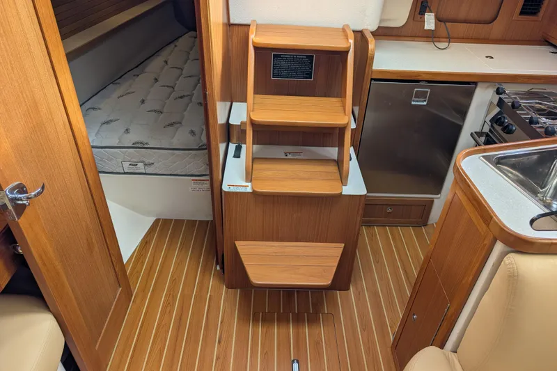 Slide: The Image of Interior of a 2021 Catalina 315 sailboat with wood finish and compact kitchen. - 9