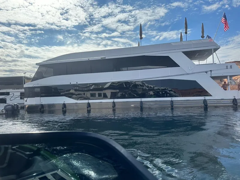 Slide: The Image of Luxury yacht Adonia on calm water under blue sky. - 2