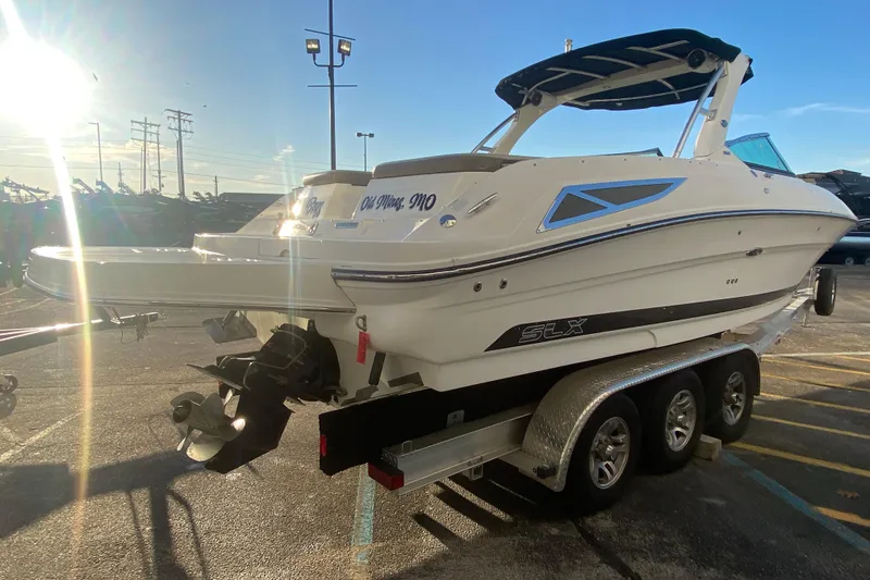 Slide: The Image of 2012 Sea Ray 300 SLX boat on trailer in sunny parking lot. - 16