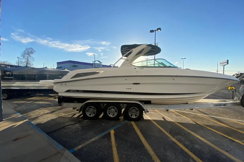 Slide: The Image of 2012 Sea Ray 300 SLX boat on trailer under clear blue sky. - 17