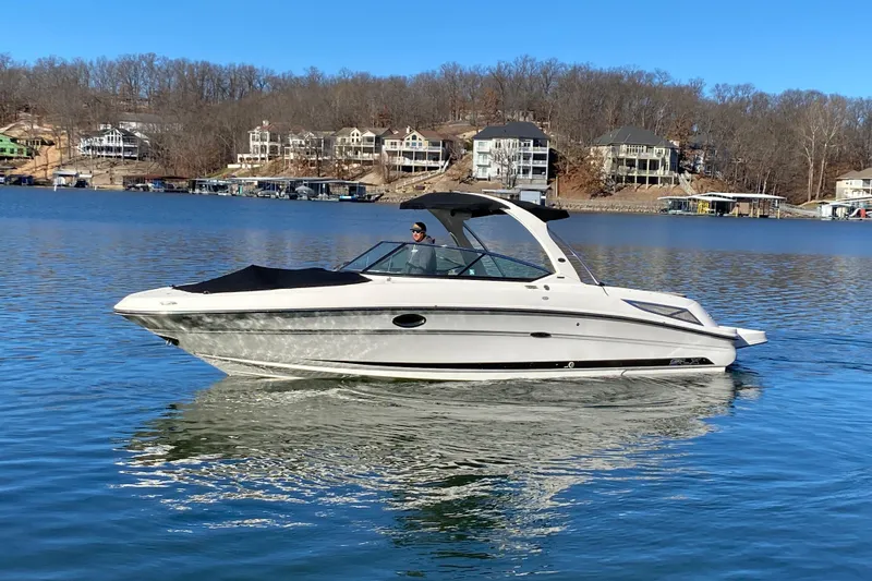 Slide: The Image of 2012 Sea Ray 300 SLX boat cruising on a serene lake with houses in the background. - 4