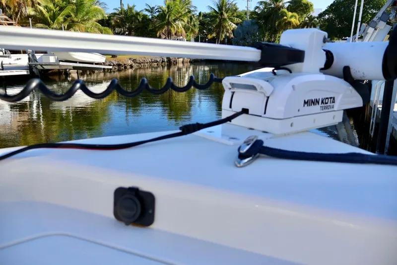 Slide: The Image of 2022 ShearWater 23LTZ boat with Minn Kota Terrova trolling motor, docked near palm trees. - 17