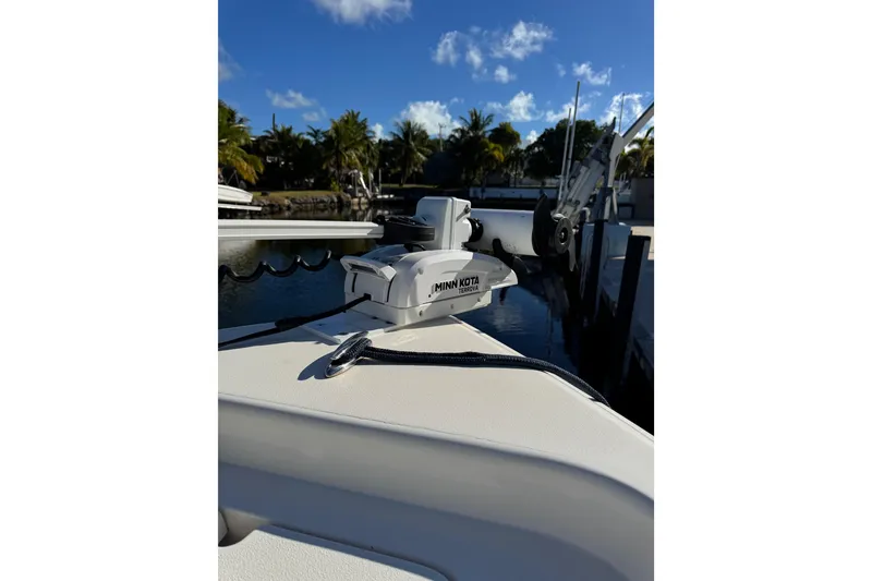 Slide: The Image of 2022 ShearWater 23LTZ boat with Minn Kota Terrova motor, docked by palm trees. - 19
