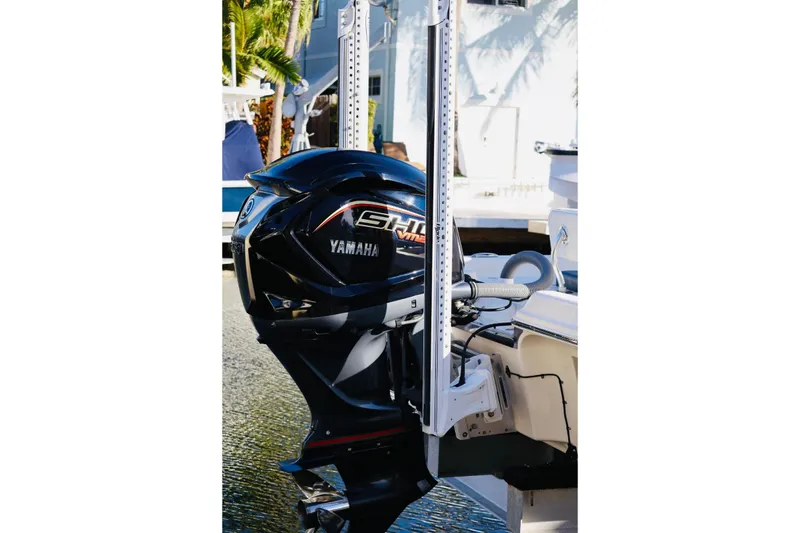 Slide: The Image of 2022 ShearWater 23LTZ boat with Yamaha outboard motor, docked near palm trees. - 4