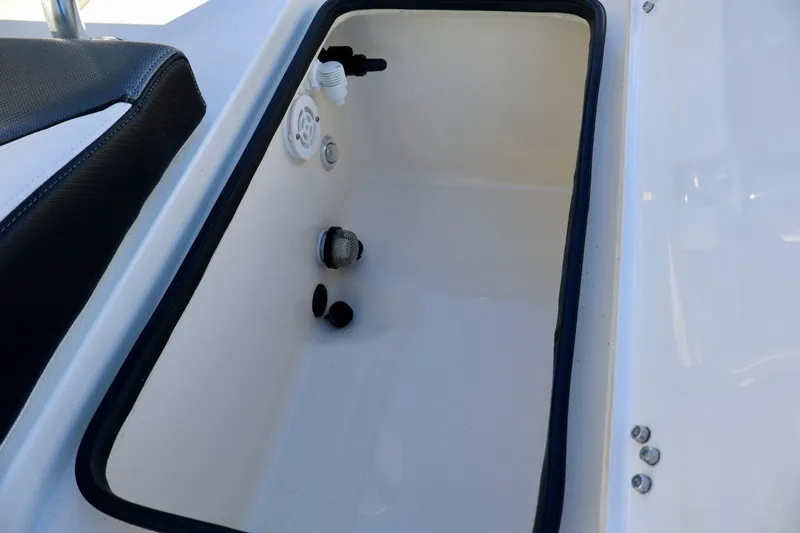 Slide: The Image of 2022 ShearWater 23LTZ boat storage compartment with black trim and fittings. - 7