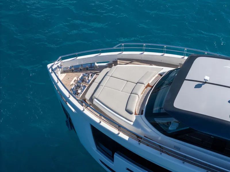 Slide: The Image of Luxurious 2025 Alpha 100 Squalo yacht deck with plush seating, overlooking serene waters and distant boats. - 15