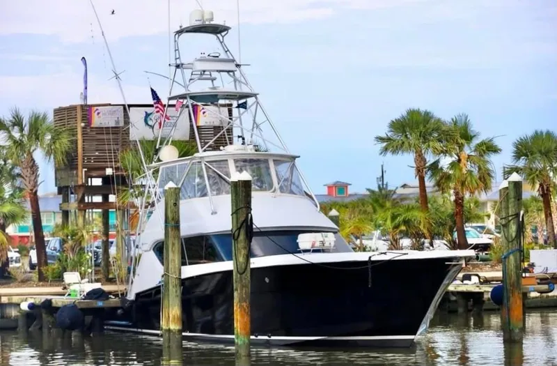 Slide: The Image of 2003 Hatteras 60 Convertible yacht docked with palm trees in background. - 4