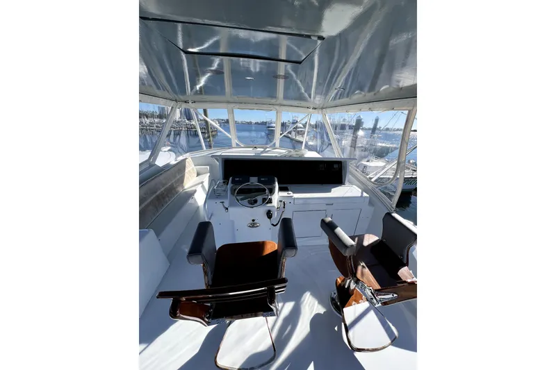 Slide: The Image of 2003 Hatteras 60 Convertible yacht helm with dual chairs and panoramic windows. - 72